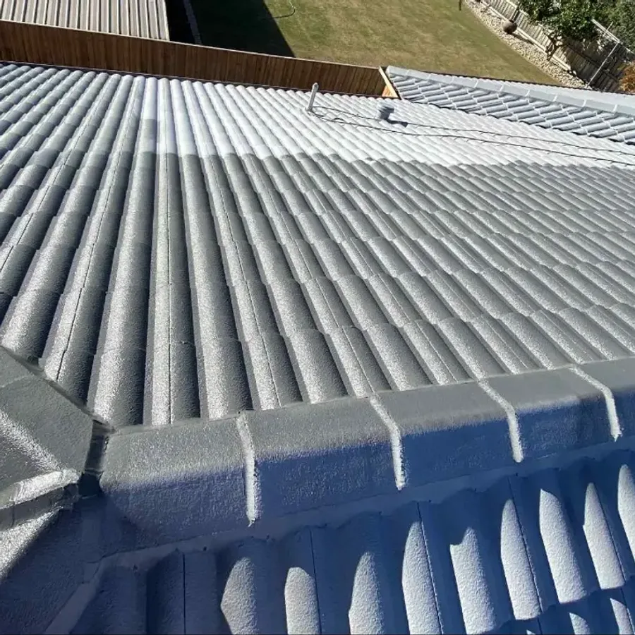 Tiled roof freshly resealed in grey during a restoration